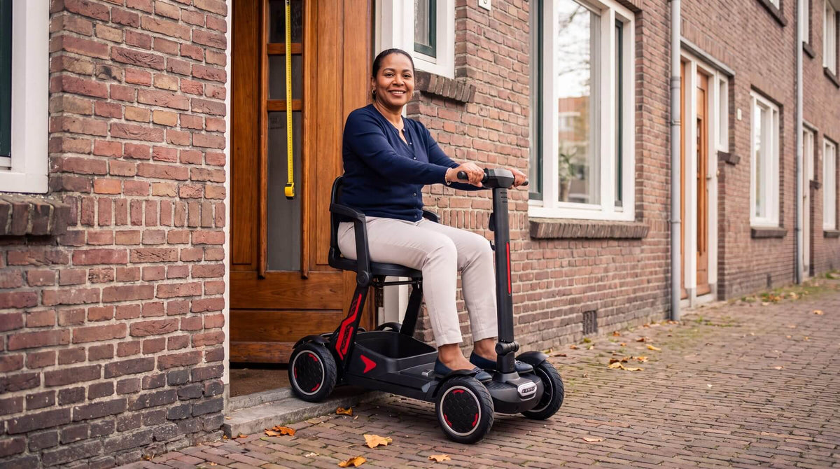 Opvouwbare scootmobiel van IVA wordt in een hal door een deuropening gemeten, afmetingen scootmobiel